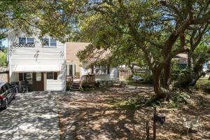 una casa con un árbol delante de ella en Sea Cave, OBX gem, private studio, couple's nest! en Kill Devil Hills