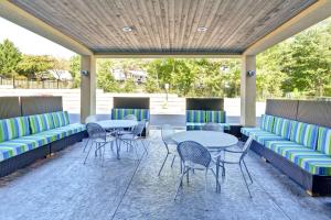 a patio with two tables and chairs and tables and chairs at Home2 Suites By Hilton Stafford Quantico in Stafford