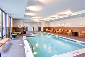 a pool in a hotel with tables and chairs at Home2 Suites By Hilton Stafford Quantico in Stafford