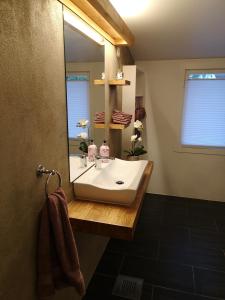 La salle de bains est pourvue d'un lavabo et d'un miroir. dans l'établissement Cosy apartment on a quiet street, à Kristiansand