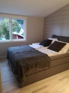 a large bed in a bedroom with a window at Cosy apartment on a quiet street in Kristiansand