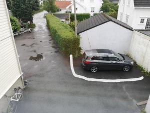 a car is parked in a parking lot at Cosy apartment on a quiet street in Kristiansand