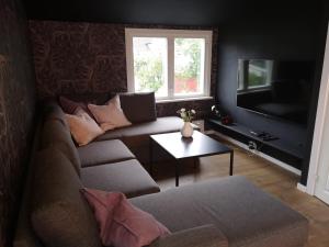 a living room with a couch and a tv at Cosy apartment on a quiet street in Kristiansand