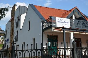 un bâtiment blanc avec une clôture noire dans l'établissement FloraVilla, à Rajecké Teplice