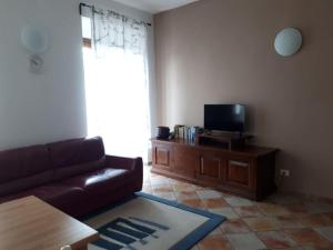 a living room with a couch and a flat screen tv at Casa Assunta in Corvara