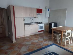 a kitchen with white cabinets and a table and a dining room at Casa Assunta in Corvara