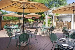 an outdoor patio with tables and chairs and umbrellas at The Desmond Hotel Malvern, a DoubleTree by Hilton in Malvern