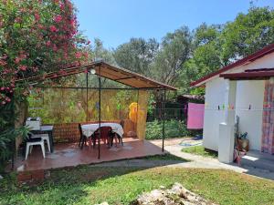 einen Pavillon mit einem Tisch und Stühlen im Hof in der Unterkunft Olive cabin - Kuća maslina i mira u Đenovićima! in Herceg-Novi