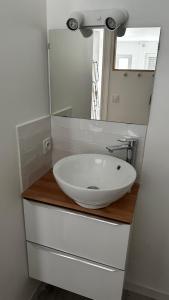 een badkamer met een witte wastafel en een spiegel bij STUDIO VUE PORT PISCINE PARKING in Cap d'Agde