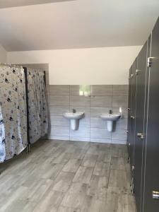 a bathroom with two sinks and two mirrors at Glamping Stodoła Dome in Ściegny