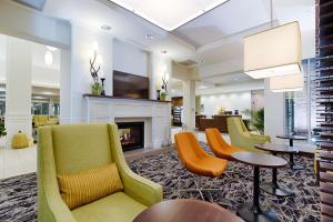 a hotel lobby with chairs and a fireplace at Hilton Garden Inn Salina in Salina