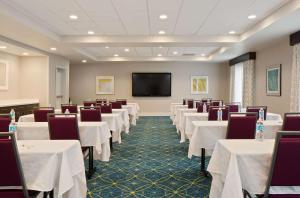 Sala de conferencias con mesas y sillas blancas y TV de pantalla plana en Hampton Inn & Suites- Seattle Woodinville Wa en Woodinville
