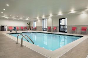 una piscina en una habitación de hotel con sillas rojas en Hampton Inn & Suites St. Louis/Alton, IL, en Alton