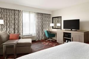 a hotel room with a bed and a flat screen tv at Hampton Inn & Suites St. Louis/Alton, IL in Alton