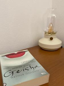 a book sitting on top of a table next to a lamp at Apartment Olea in Izola