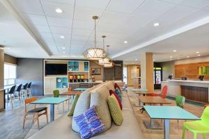 a lobby with a couch and tables and a bar at Home2 Suites By Hilton Dayton Vandalia in Dayton