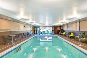 a pool in a hotel with tables and chairs at Home2 Suites By Hilton Dayton Vandalia in Dayton