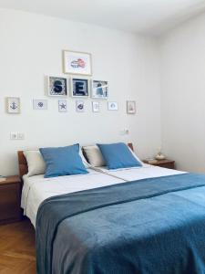 a bedroom with a bed with blue sheets and pictures on the wall at Apartment Olea in Izola