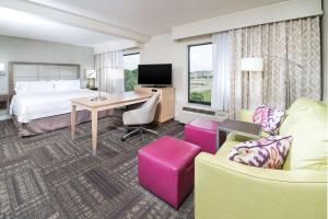 een hotelkamer met een bed, een bureau en stoelen bij Hampton Inn & Suites Wilson I-95 in Wilson