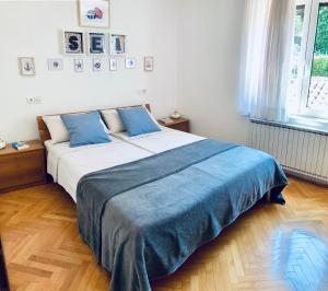 a bedroom with a large bed with blue pillows at Apartment Olea in Izola