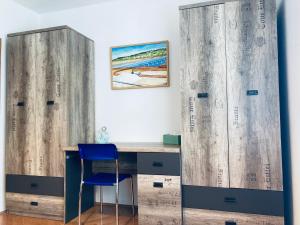 a desk with a blue chair in a room with wooden walls at Apartment Olea in Izola