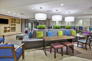 una sala de espera con sofá, mesas y sillas en Home2 Suites By Hilton Pittsburgh Area Beaver Valley, en Monaca