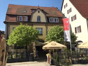 ein Gebäude vor einem Gebäude mit Sonnenschirmen in der Unterkunft Gasthof Hotel Bauer in Hersbruck