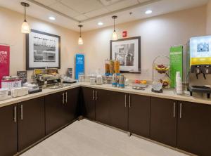 a kitchen with brown cabinets and a counter at Hampton Inn Covington VA in Covington