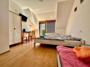 a room with two beds and a table in it at Leniwy Kot in Stegna