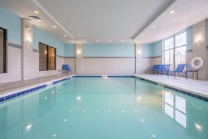 拉戈的住宿－格倫登/華盛頓特區漢普頓套房酒店，大楼内带蓝色椅子的游泳池
