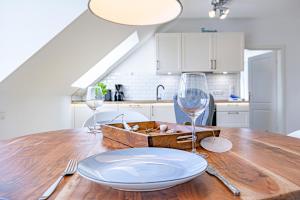 - une table en bois avec une assiette et deux verres à vin dans l'établissement Eckhus 54°, à Büsum