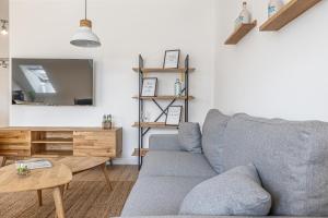 uma sala de estar com um sofá cinzento e uma mesa em Eckhus 54° em Büsum