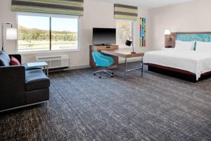 a hotel room with a bed and a desk with a computer at Hampton Inn Suites Flagstaff East in Flagstaff