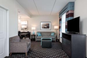 sala de estar con sofá y TV de pantalla plana en Homewood Suites By Hilton Fayetteville, en Fayetteville