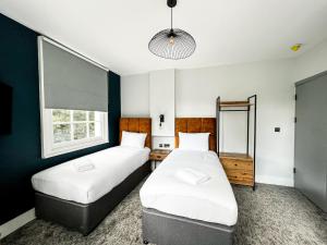 Cette chambre comprend 2 lits et une fenêtre. dans l'établissement Argo Hotel - Kings Cross, à Londres