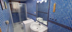 a blue tiled bathroom with a toilet and a sink at Apartamento El Refugio de Sara in Benasque +48 photos