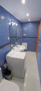 a blue tiled bathroom with a toilet and a sink at Apartamento El Refugio de Sara in Benasque