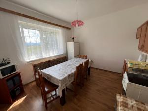 a kitchen with a table with chairs and a refrigerator at Lorka in Bobrovec