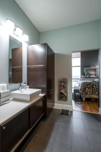 a bathroom with a sink and a bed at Lux living in this 6th floor condo located in East Nashville minutes to downtown in Nashville