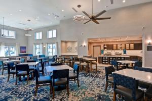 a restaurant with tables and chairs and a ceiling at Homewood Suites By Hilton New Orleans West Bank Gretna in Gretna