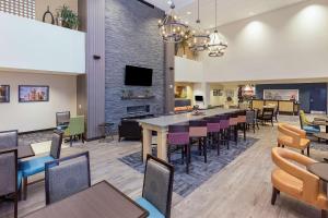 モーガンタウンにあるHampton Inn & Suites Morgantown / University Town Centreのテーブルと椅子、暖炉のあるレストラン