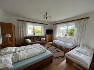 1 dormitorio con 2 camas, sofá y silla en Lorka, en Bobrovec