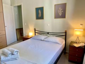 1 dormitorio con 1 cama con 2 toallas en 100 meters from the sea, en Xylokastro