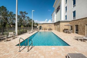 a swimming pool in front of a building at Hampton Inn & Suites West Melbourne-Palm Bay Road in Melbourne