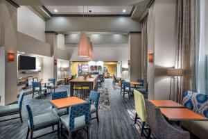 una sala da pranzo con tavoli e sedie e una caffetteria di Hampton Inn & Suites West Melbourne-Palm Bay Road a Melbourne