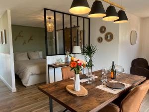una sala da pranzo con un tavolo con fiori e un letto di Cottage à la campagne a Quimerch