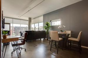 a living room with a couch and a table and chairs at Sleek and Spacious Condo In East! in Nashville