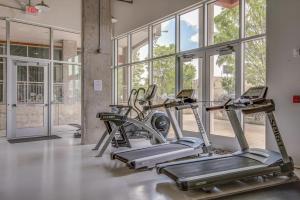 a gym with two treadmills in a room with windows at Sleek and Spacious Condo In East! in Nashville