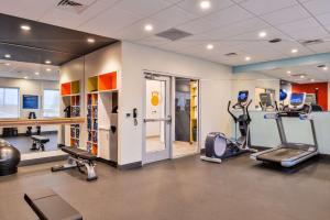 una palestra con tapis roulant ed ellittiche in una stanza di Tru By Hilton Stuttgart a Stuttgart