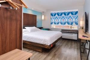 una camera da letto con un letto e una grande finestra di Tru By Hilton Stuttgart a Stuttgart